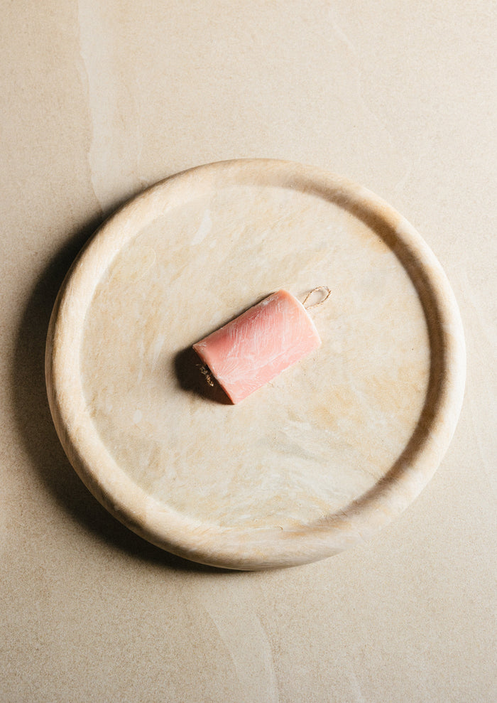 Bikini Care cleanser bar on a stone dish
